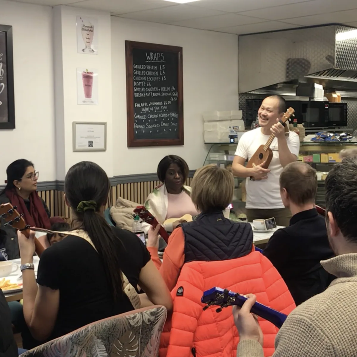 Beginners smiling with ukuleles at a previous in-person workshop
